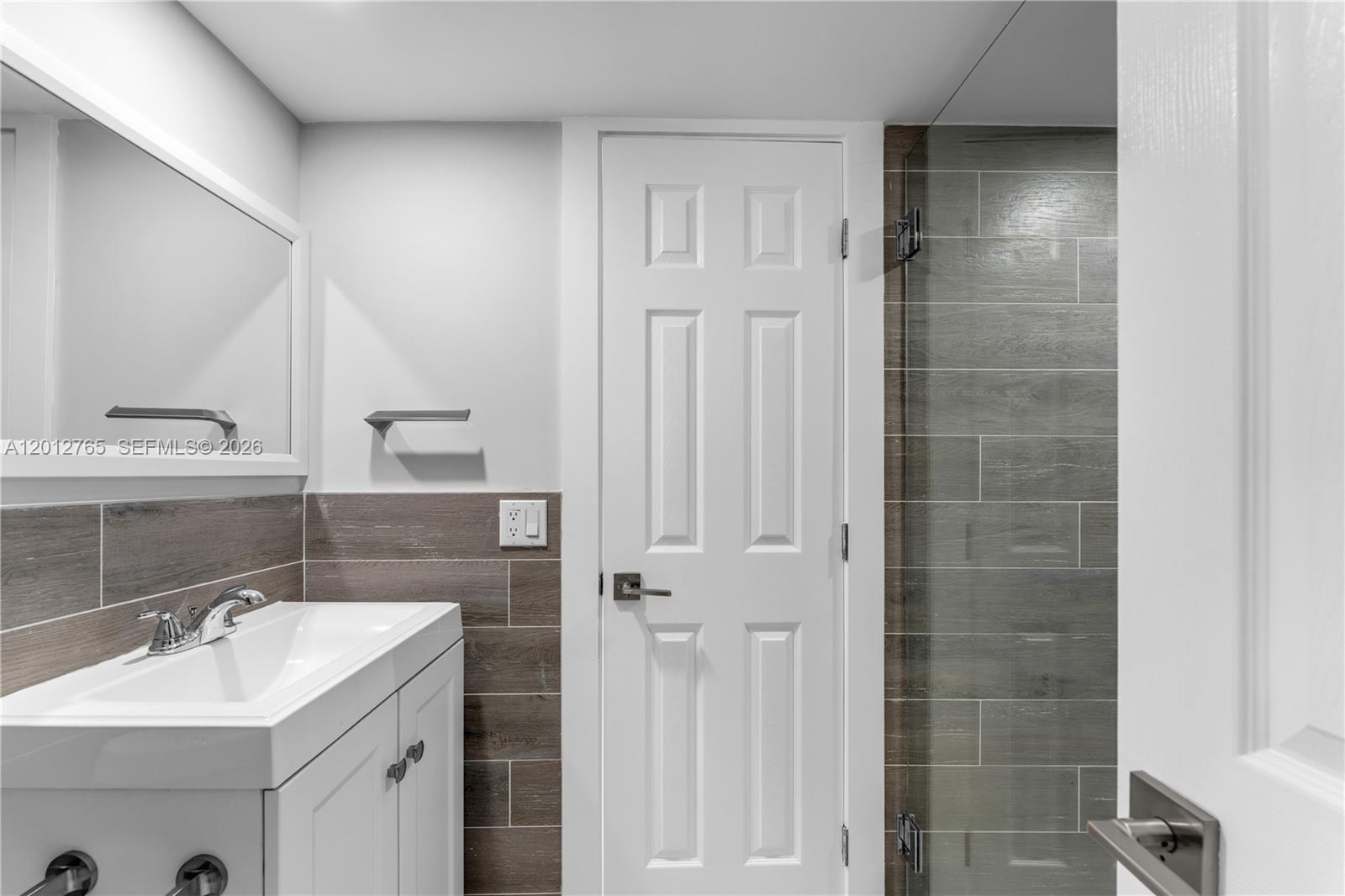 6327 Southwest 127th Place Miami, FL 33183 - Photo 29 of 48 a bathroom with a double vanity sink a mirror and a shower