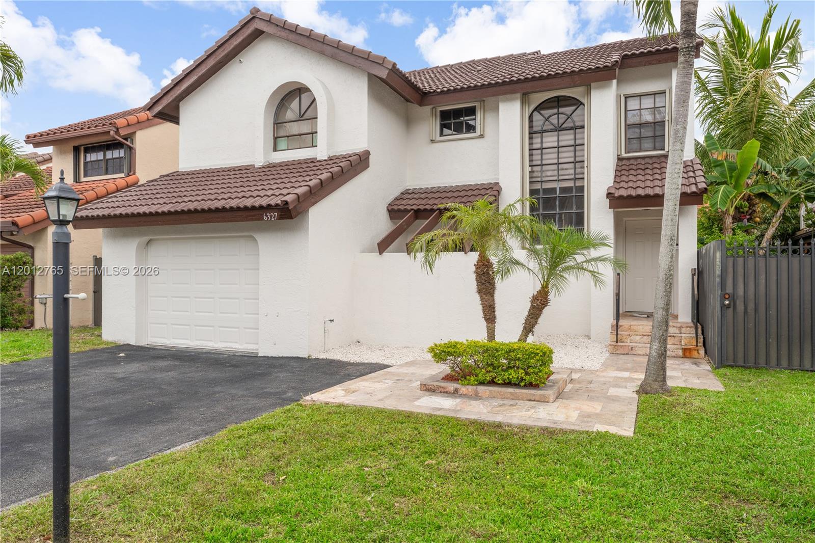 6327 Southwest 127th Place Miami, FL 33183 - Photo 3 of 48 a front view of a house with a garden