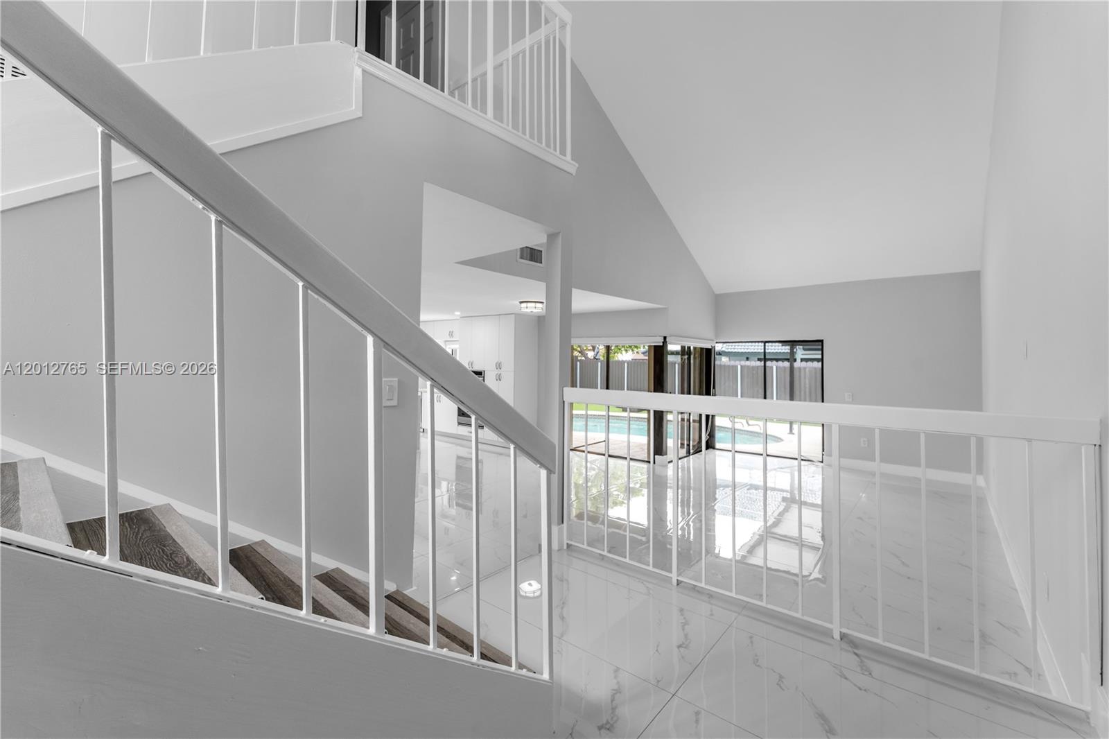 6327 Southwest 127th Place Miami, FL 33183 - Photo 5 of 48 a view of staircase with lots of frames on wall and windows