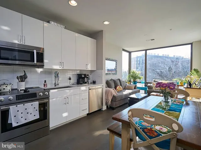 a open kitchen with stainless steel appliances granite countertop a stove a sink dishwasher and a microwave with wooden floor