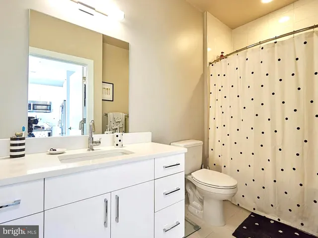 a bathroom with a sink toilet vanity and shower