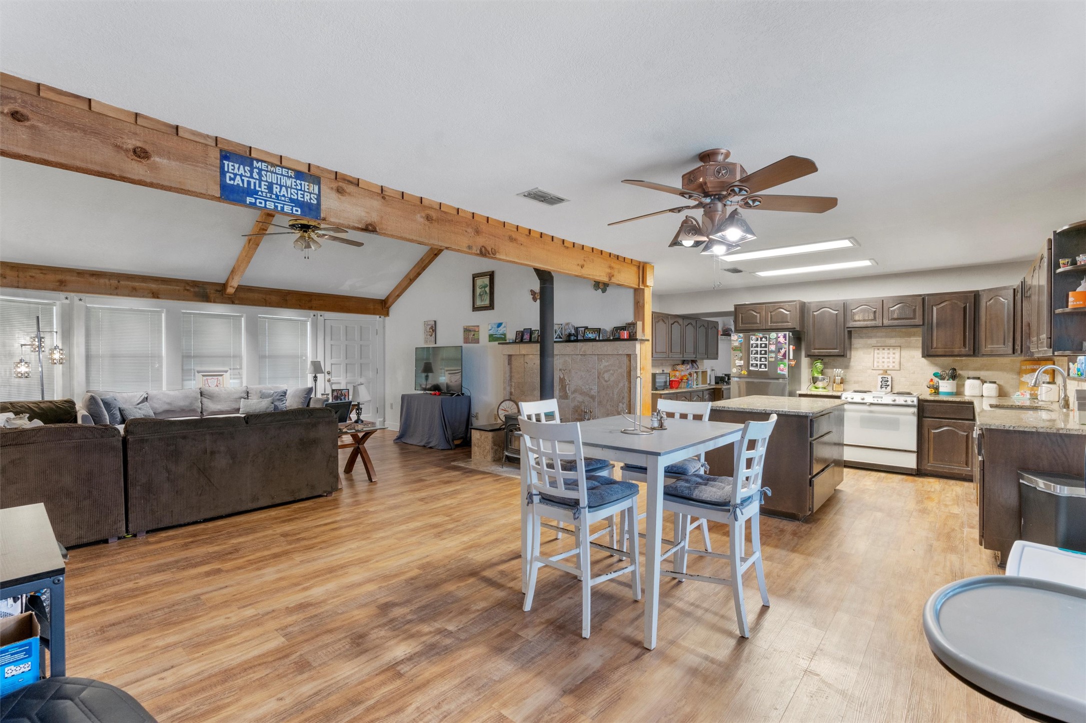 1000 County Road 215 Florence, TX 76527 - Photo 17 of 40 a dining room with wooden floor a chandelier a wooden table and chairs