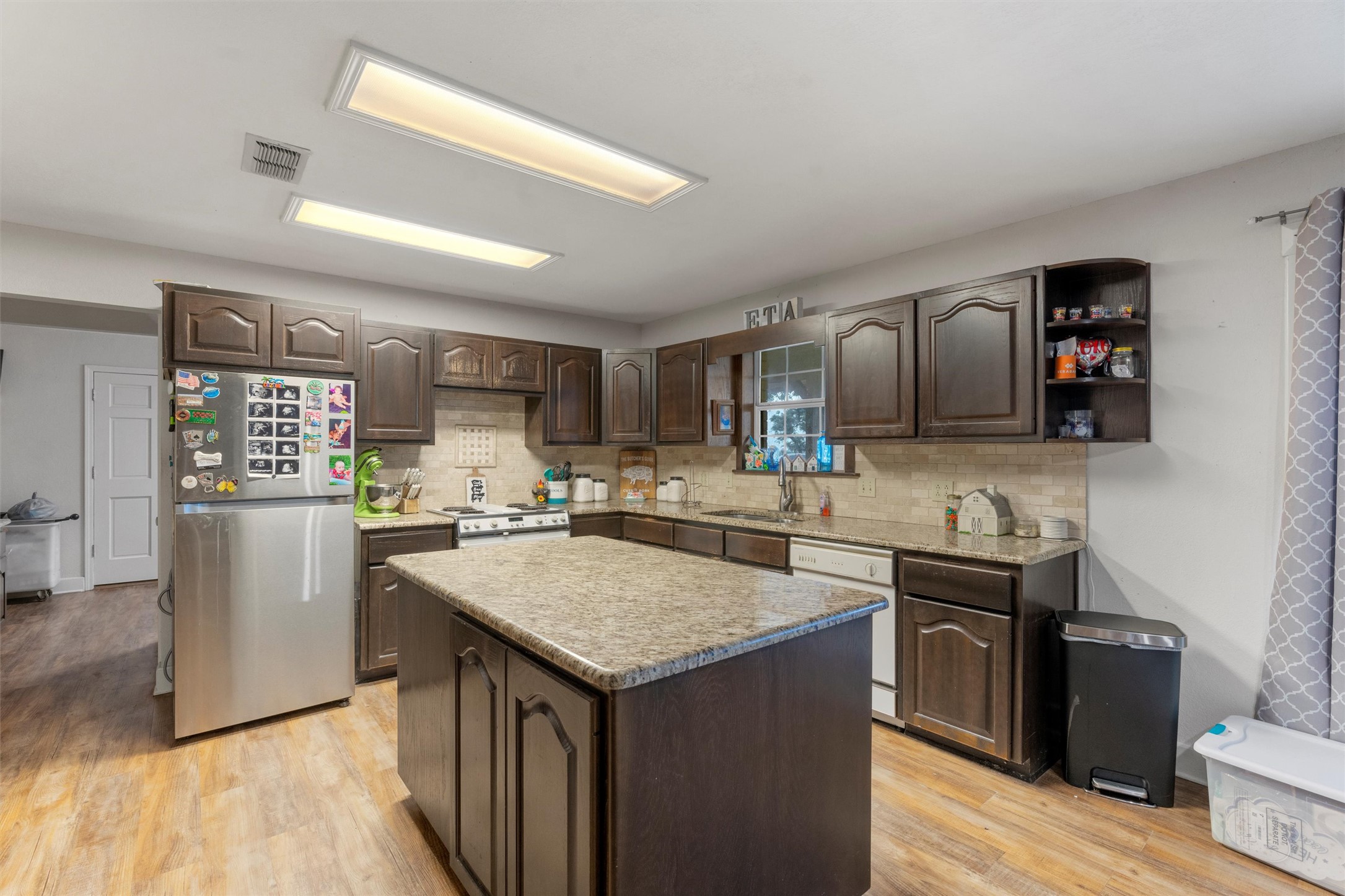 1000 County Road 215 Florence, TX 76527 - Photo 18 of 40 a kitchen with granite countertop a sink a counter space and stainless steel appliances