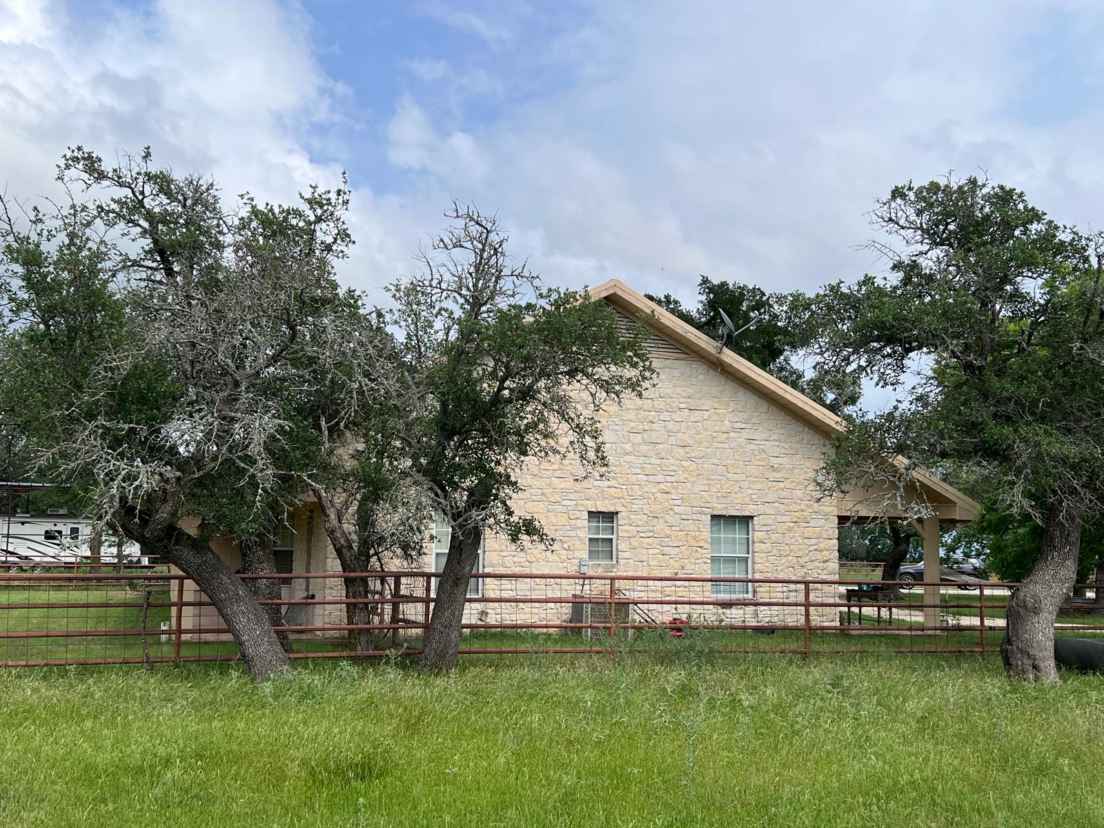 1000 County Road 215 Florence, TX 76527 - Photo 38 of 40 a view of a white house with a big yard and a large tree