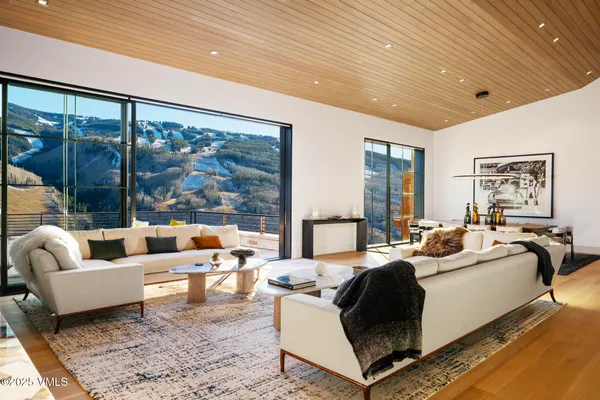 a living room with furniture large windows and a rug