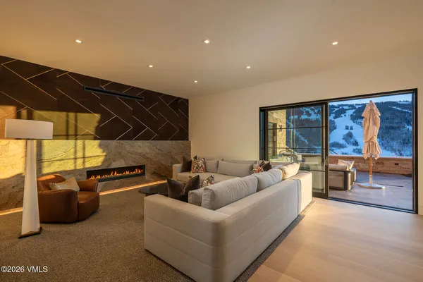 a living room with furniture a flat screen tv and a floor to ceiling window