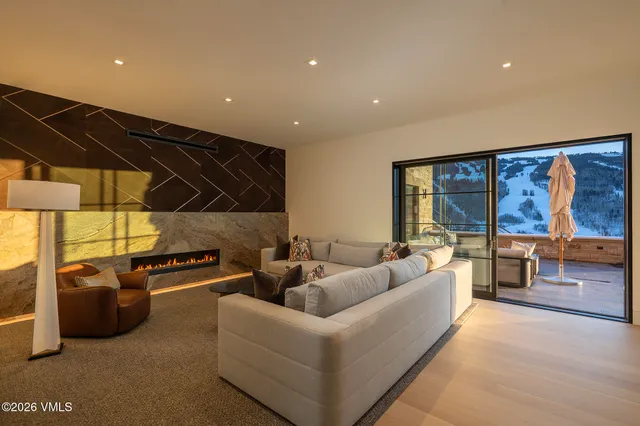a living room with furniture a flat screen tv and a floor to ceiling window