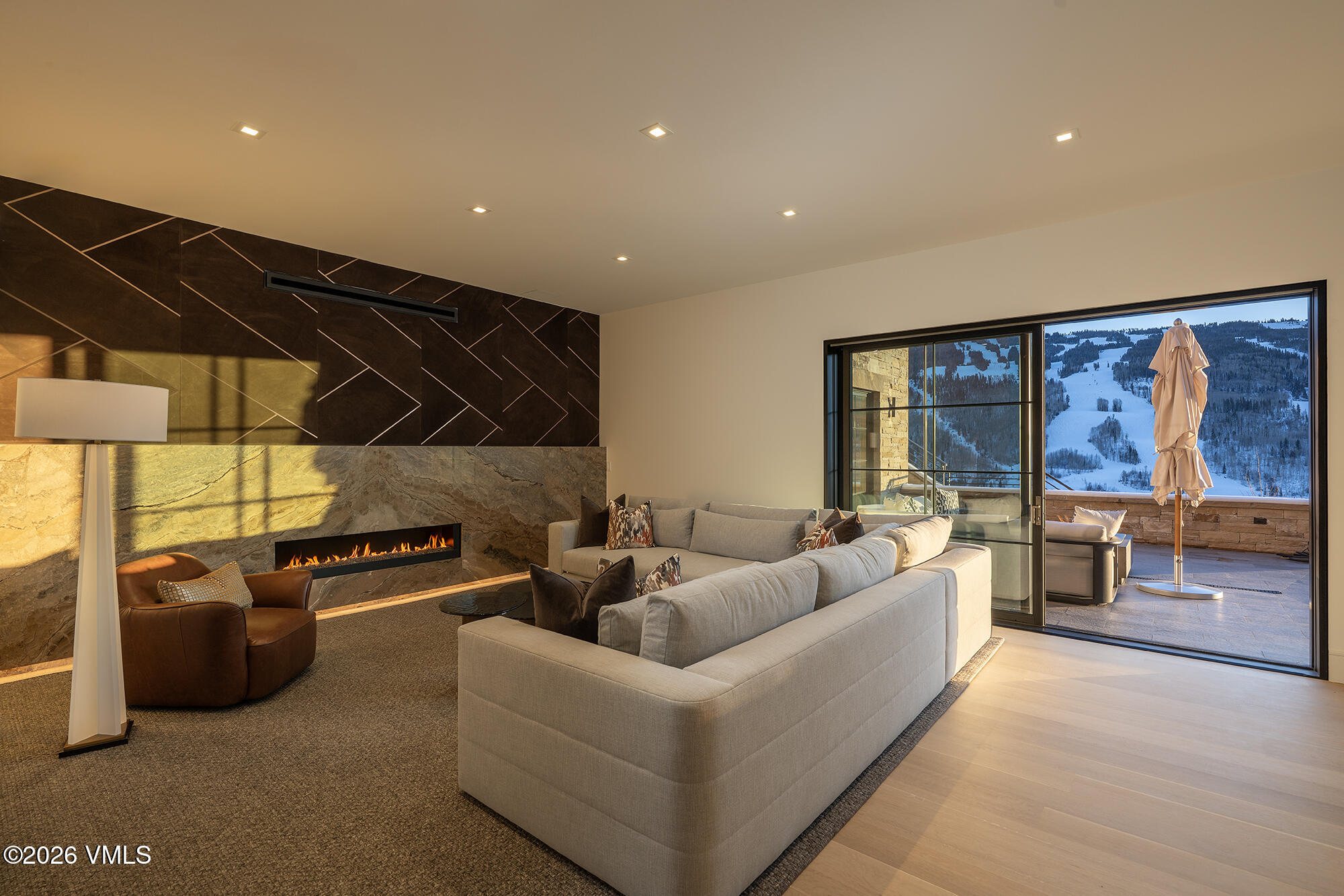 1326 Spraddle Creek Road Vail, CO 81657 - Photo 9 of 26 a living room with furniture a flat screen tv and a floor to ceiling window