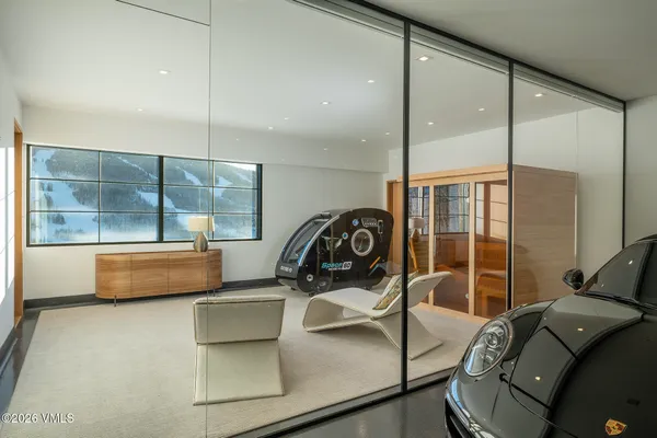 a gym room with large glass windows and furniture