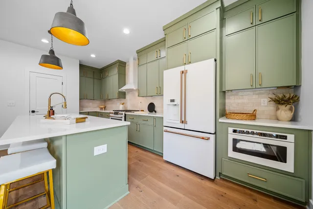 a kitchen with a sink a refrigerator and a stove top oven