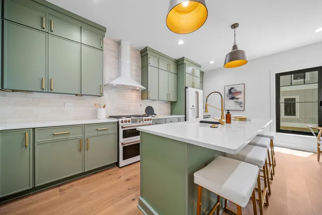 a kitchen with stainless steel appliances granite countertop a sink a stove and a wooden floors
