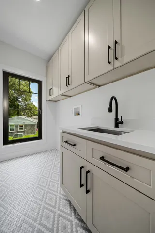a kitchen with white cabinets and window