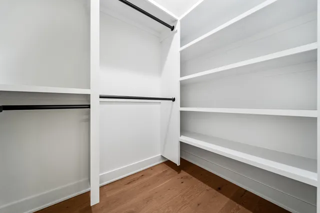 a view of walk in closet with empty racks