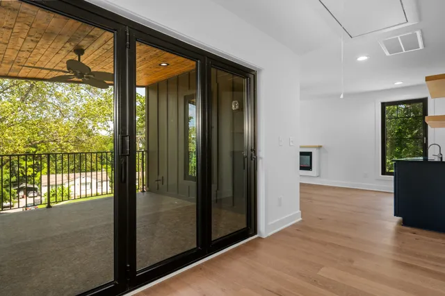 a view of a hallway with wooden floor and a living room