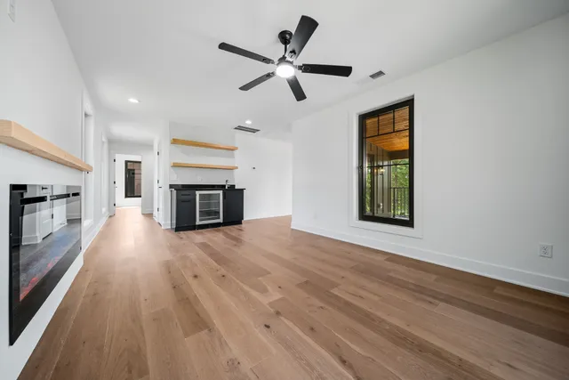 a view of empty room with wooden floor and fireplace