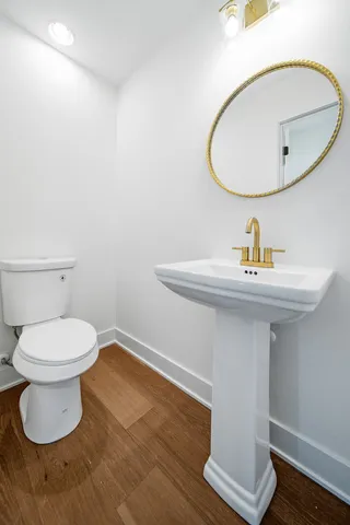 a bathroom with a sink toilet and a mirror