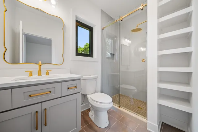 a bathroom with a sink a toilet and shower