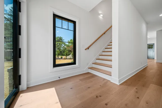 a view of a hallway with stairs and a window