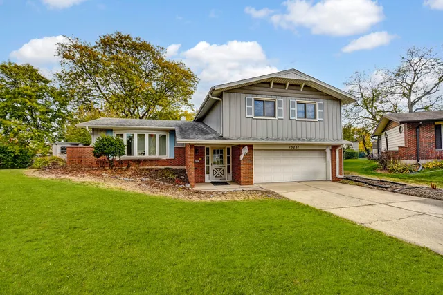 a front view of a house with a yard and trees