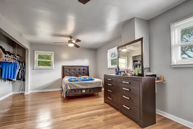 a bedroom with a bed and a mirror on the dresser