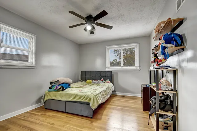 a bedroom with a bed and wooden floor