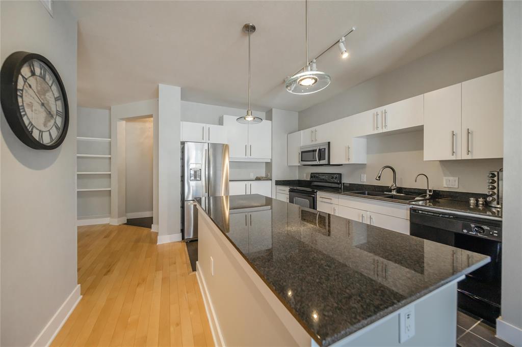 4414 Cedar Springs Road, Unit 214 Dallas, TX 75219 - Photo 6 of 29 Kitchen featuring pendant lighting, black appliances, white cabinetry, and dark stone counters