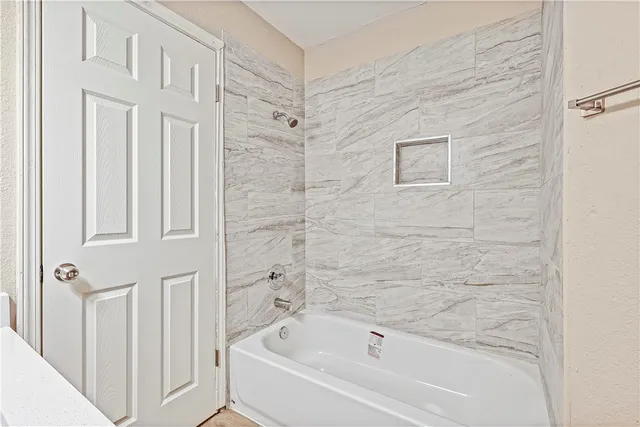 a bathroom with bathtub and shower