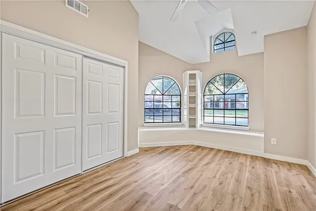 an empty room with wooden floor windows and outdoor view