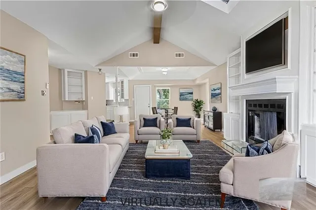 a living room with furniture a fireplace and a flat screen tv