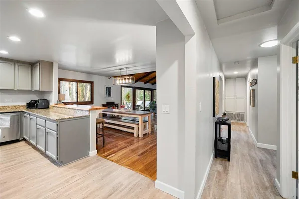 a kitchen with a refrigerator and wooden floor