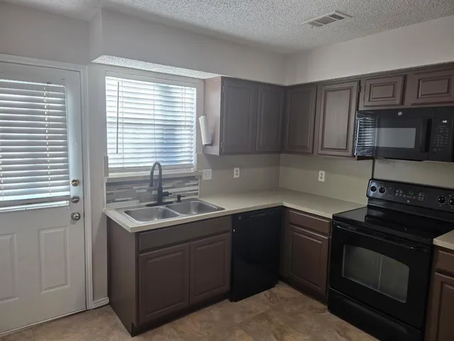 a kitchen with a sink stove and cabinets