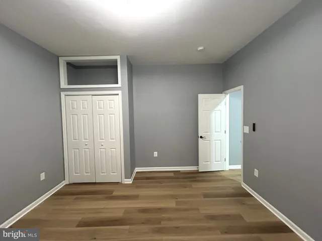 an empty room with wooden floor and closet