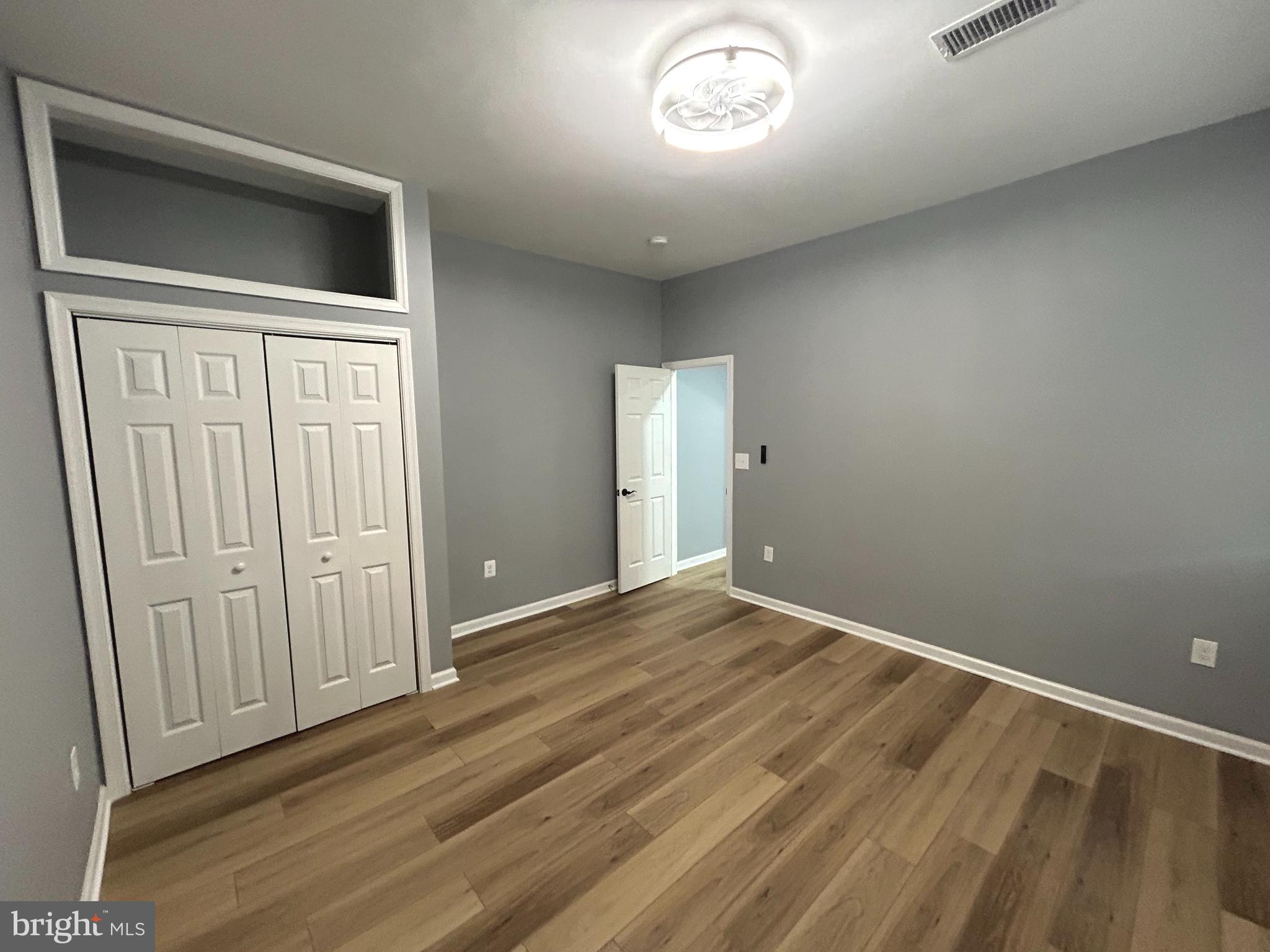 3902 West Rogers Avenue, Unit 1 Baltimore, MD 21215 - Photo 6 of 12 a view of an empty room with wooden floor and a window