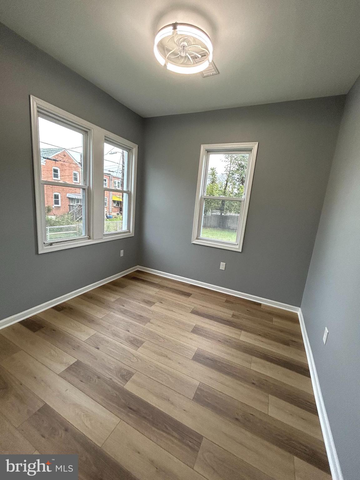 3902 West Rogers Avenue, Unit 1 Baltimore, MD 21215 - Photo 7 of 12 an empty room with wooden floor and windows