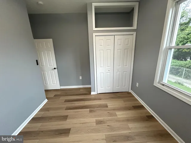 a view of a hallway with wooden floor and a window