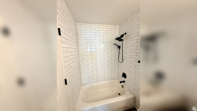 11895 Inauguration Road Draper, UT 84020 - Photo 7 of 10 Bathtub with white subway tile surround, matte black showerhead, and coordinating bath fixtures