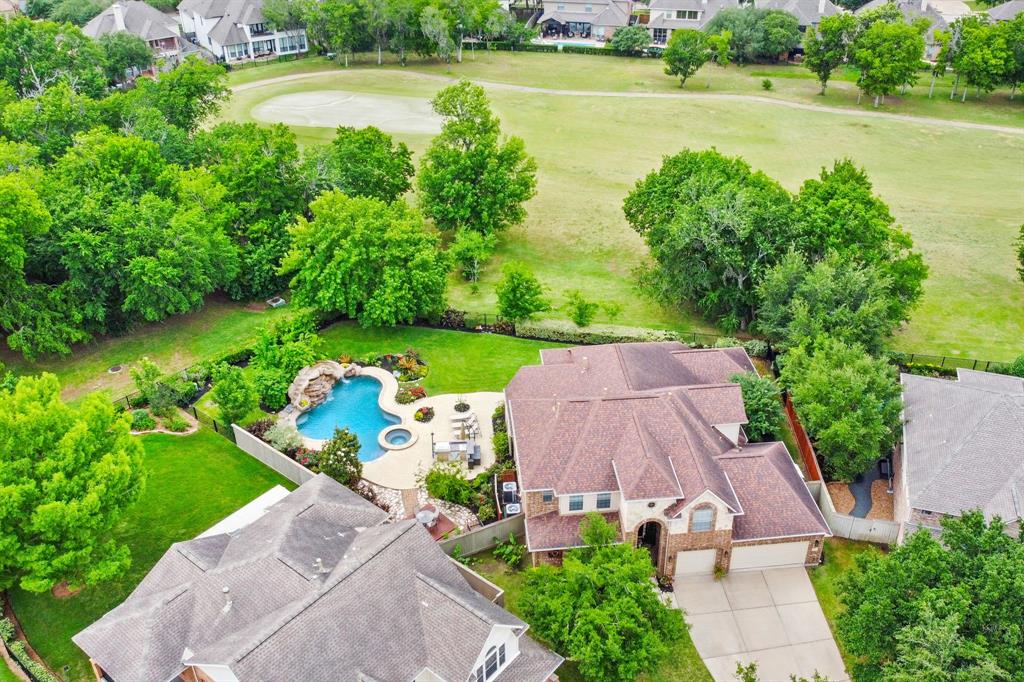 an aerial view of a house with garden space and swimming pool