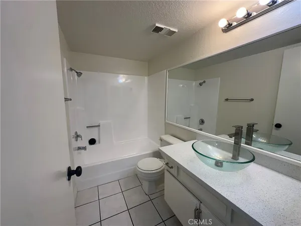 a view of an empty room with wooden floor and closet