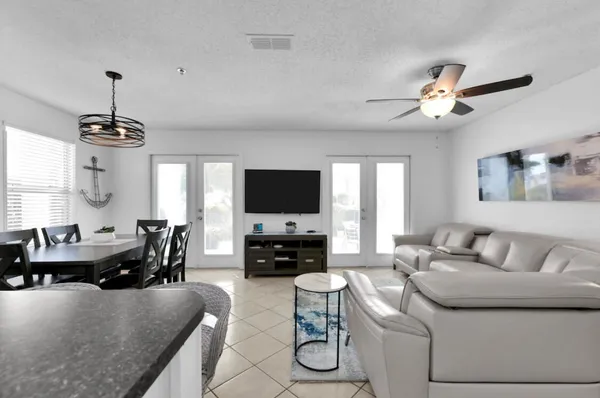 a living room with furniture a chandelier and a flat screen tv