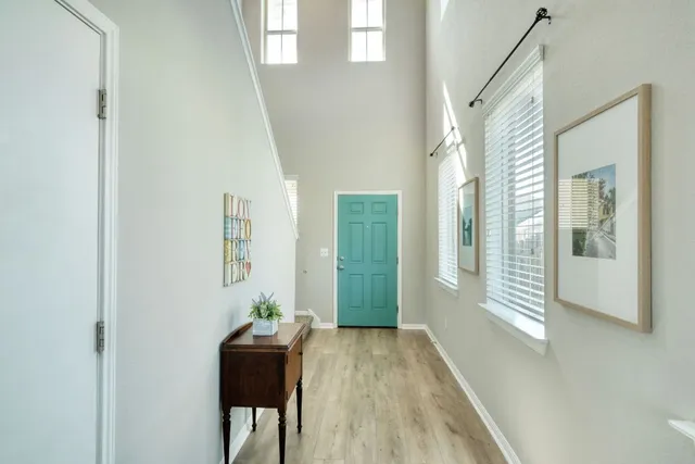 a view of a hallway with wooden floor and furniture