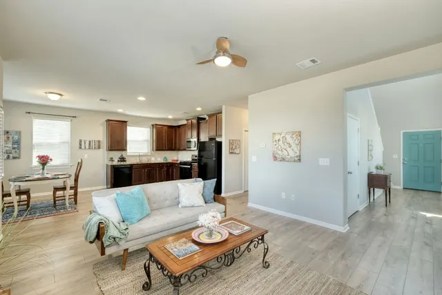 a living room with furniture and kitchen view