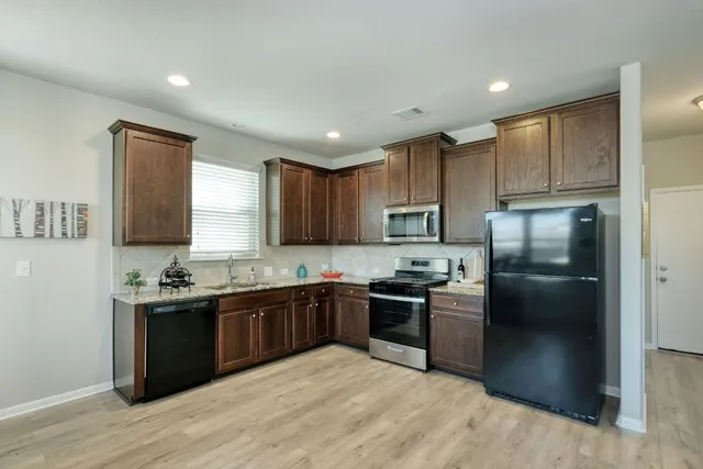 a living room with furniture kitchen view and a large window