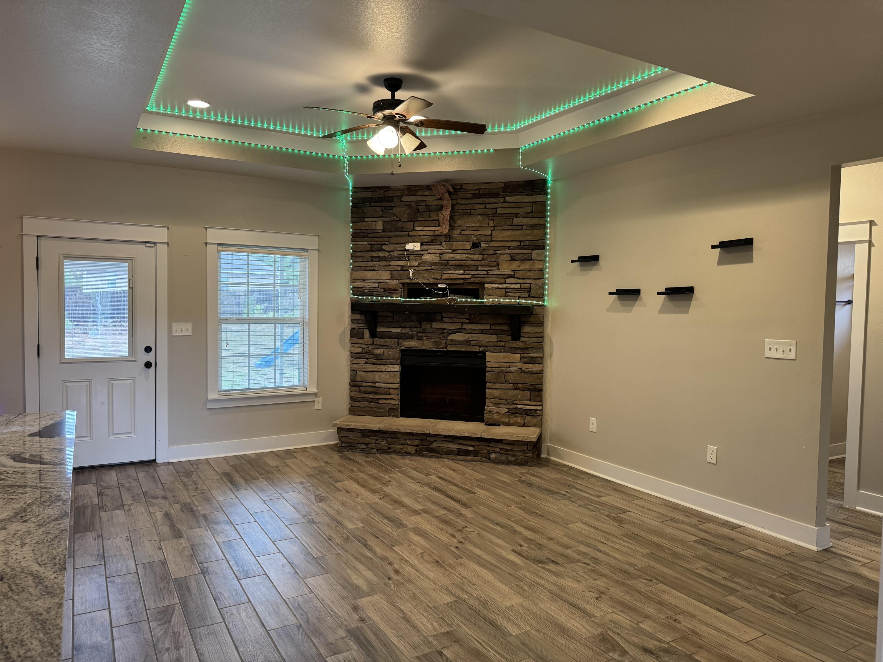 4075 Happy Trails Road Crestview, FL 32539 - Photo 2 of 11 a view of an empty room with wooden floor fireplace and a window