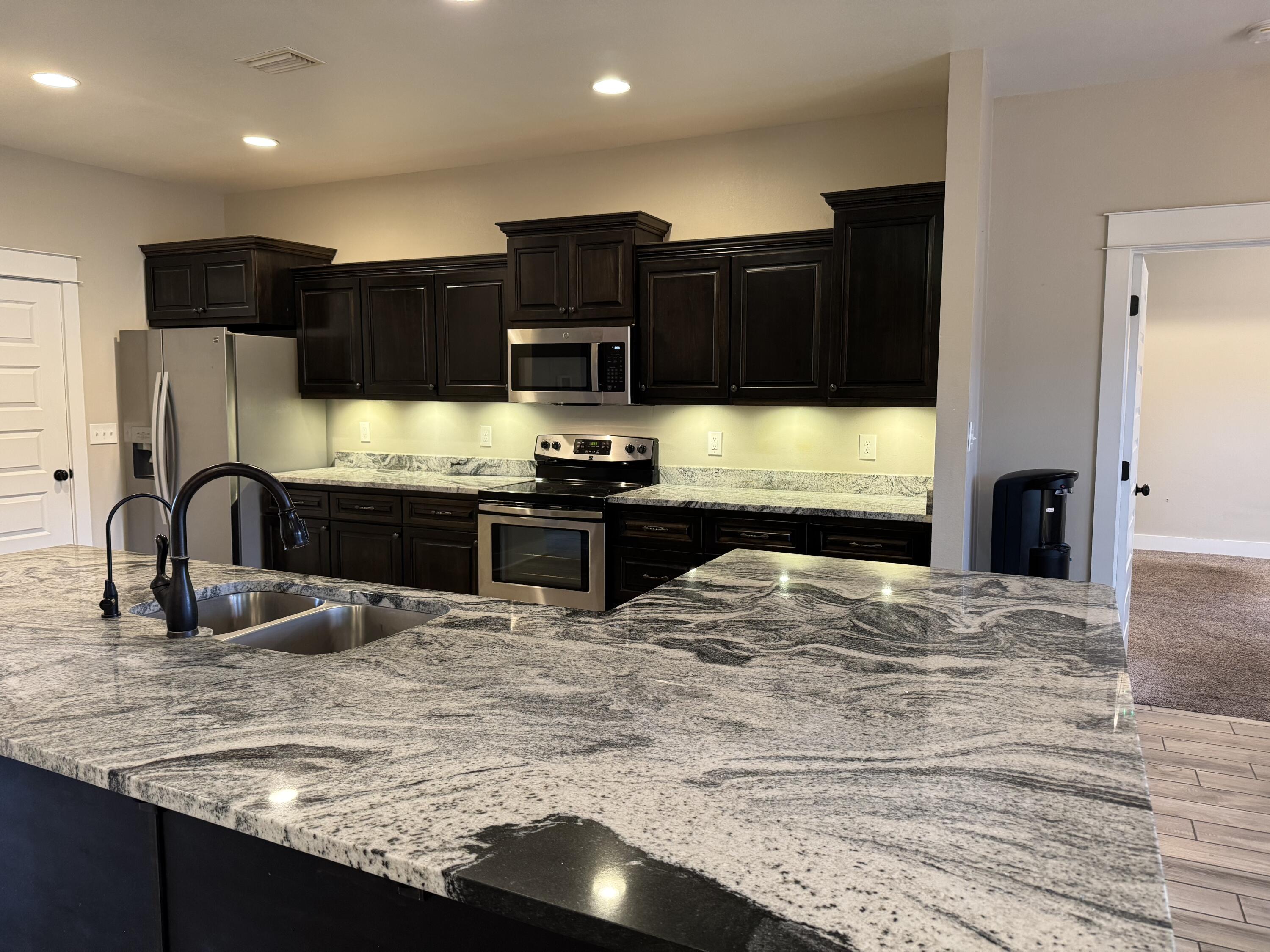 4075 Happy Trails Road Crestview, FL 32539 - Photo 3 of 11 a kitchen with stainless steel appliances wooden cabinets a sink and a stove