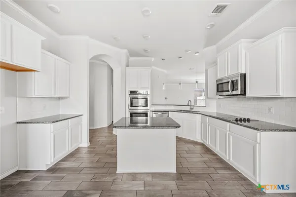 a large white kitchen with cabinets