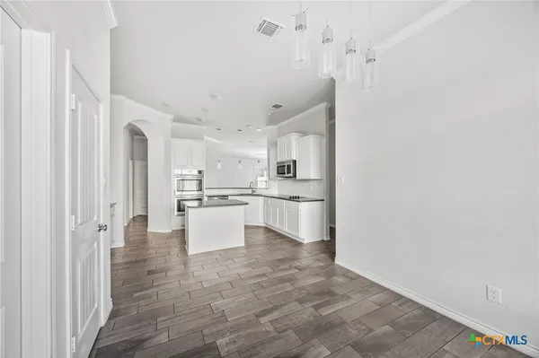a kitchen with white cabinets and white appliances