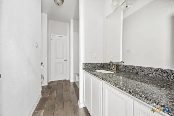 a bathroom with a granite countertop sink and a granite