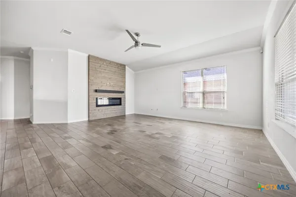 an empty room with windows and fireplace
