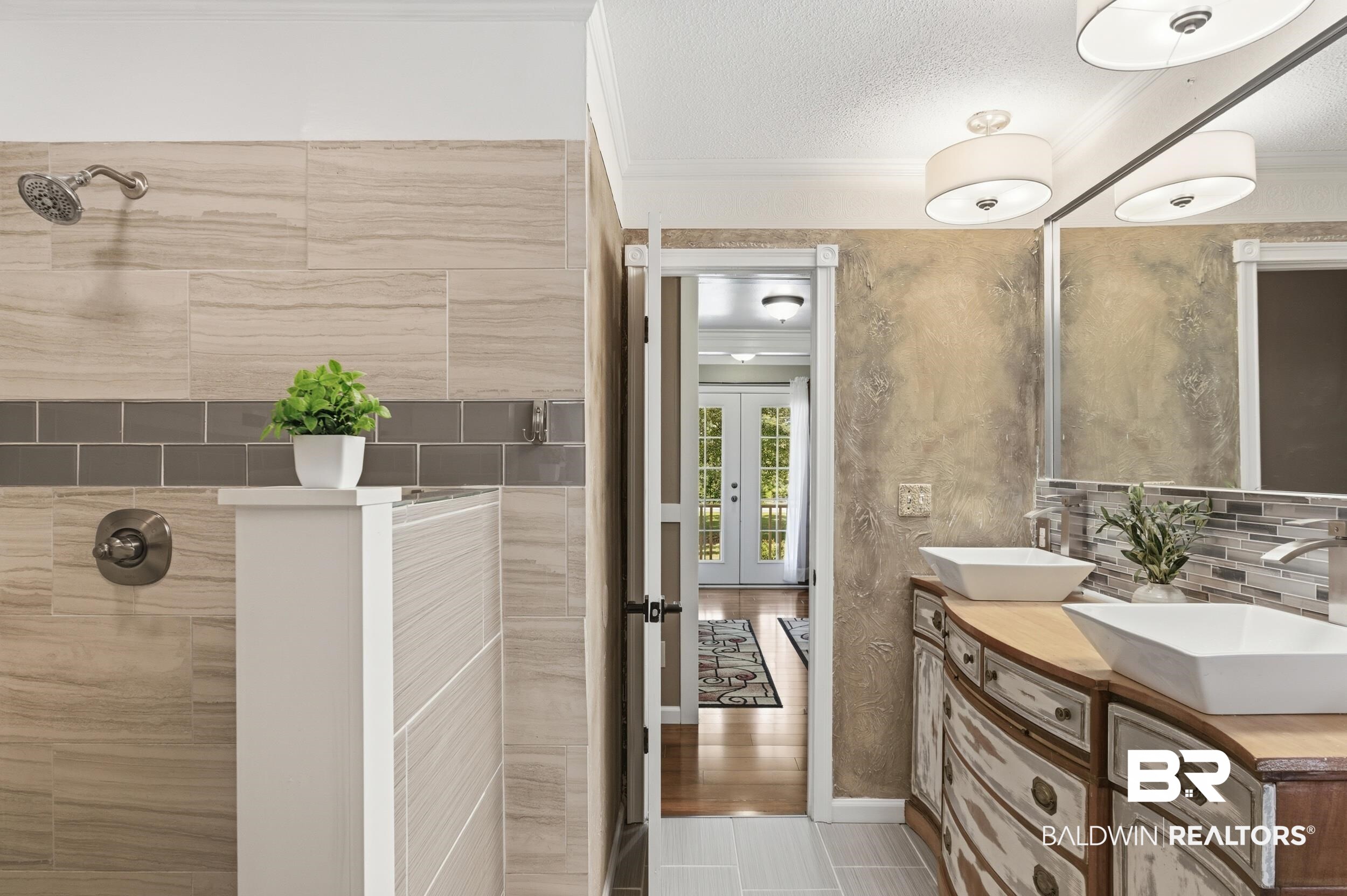 51620 Robert White Road Bay Minette, AL 36507 - Photo 50 of 81 Bathroom featuring a curved double vanity with vessel sinks, a glass tile backsplash, and overhead drum light fixtures
