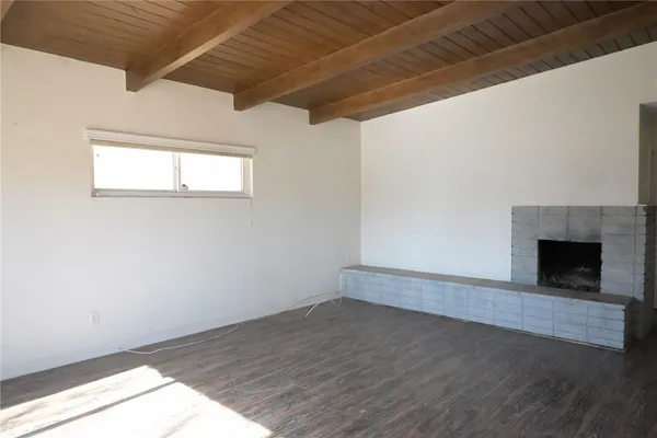 a view of empty room with wooden floor and fireplace